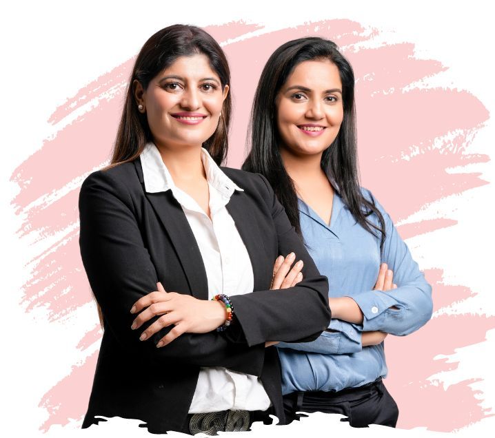 Photo of two women smiling posed with their arms crossed. Background is white with a large pink paint stroke.